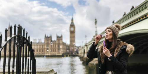 UK, London, young woman blowing soap bubbles